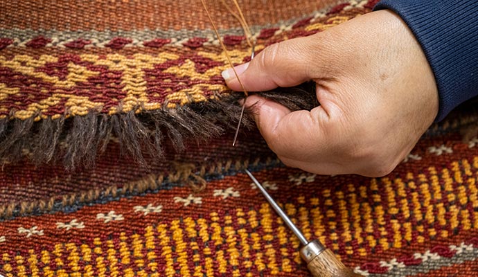 Repairing a rug fringe with equipment