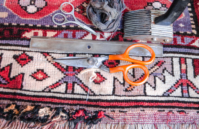 Fringe repair services being performed on a rug