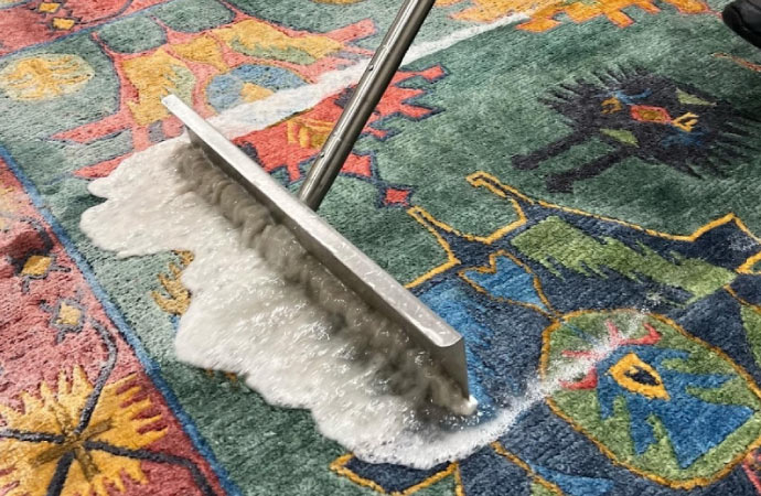 worker cleaning rug