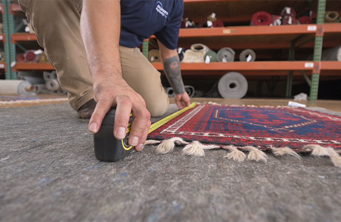 Person taking measurement of a rug