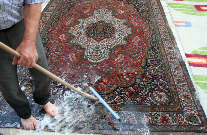 worker cleaning tibetan rug